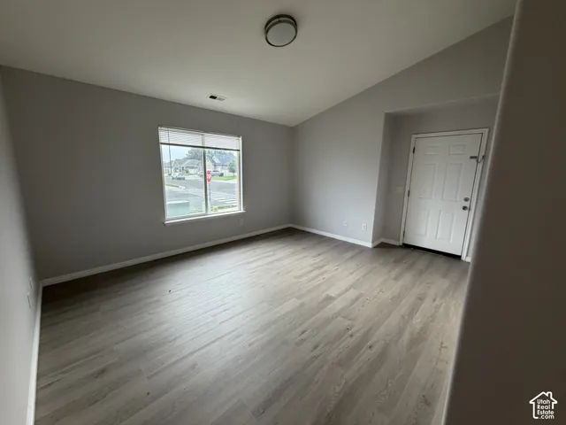 Primary Bedroom featuring LVP flooring, a white paneled exterior door, and a large window with white blinds