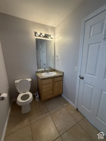 Vanity with a granite countertop, integrated sink, and wood-finish cabinetry