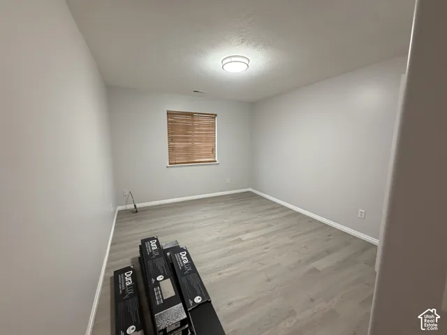 Bedroom 3 with LVP flooring, neutral wall tones, window with natural wood blinds, and a flush mount ceiling light