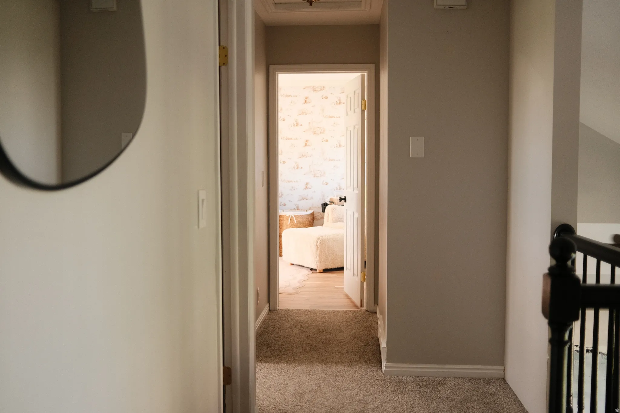 Carpeted hallway with light gray walls and white trim