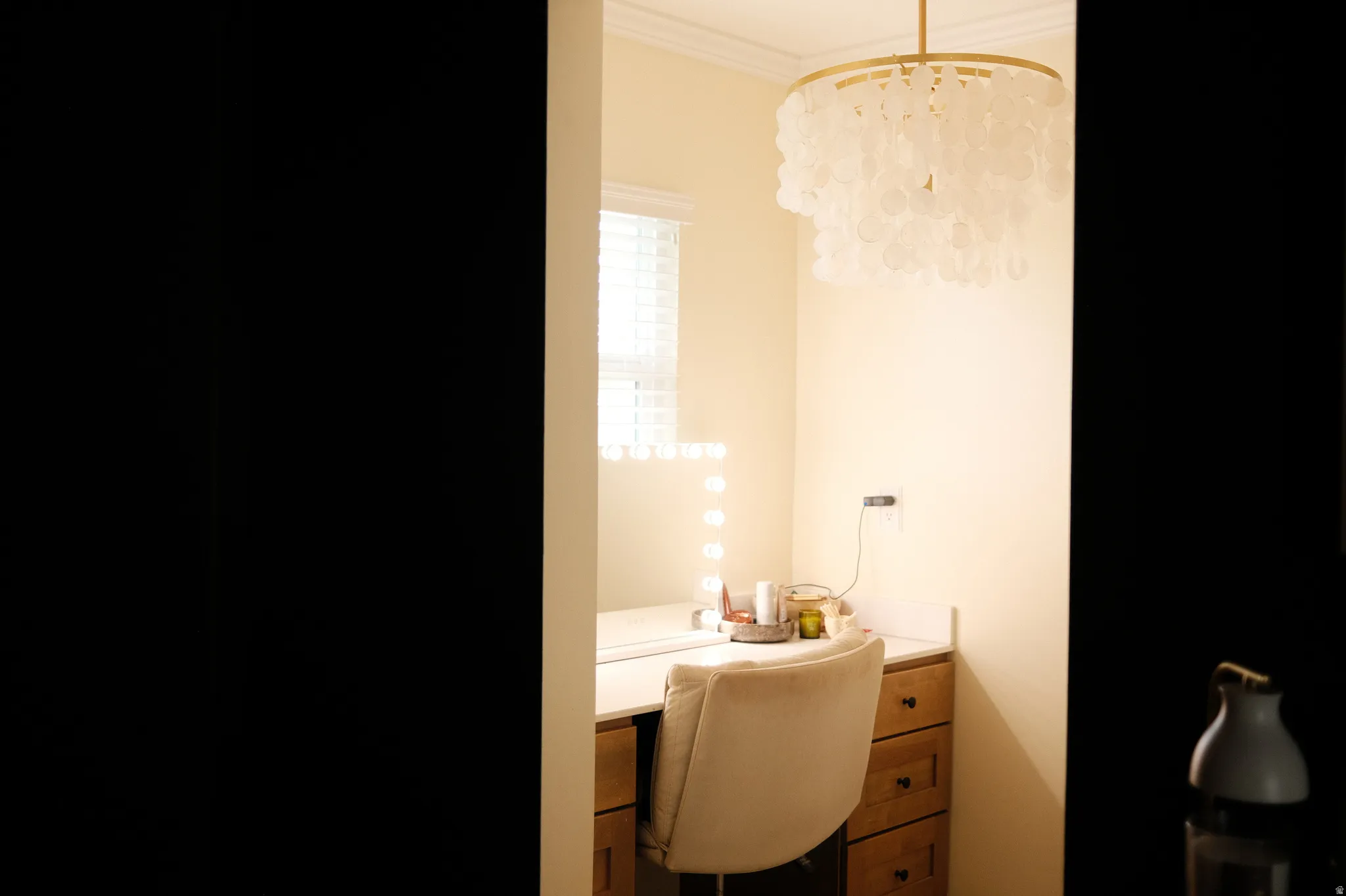Integrated vanity space featuring a built-in countertop, wooden cabinetry with drawers, and a window with horizontal blinds