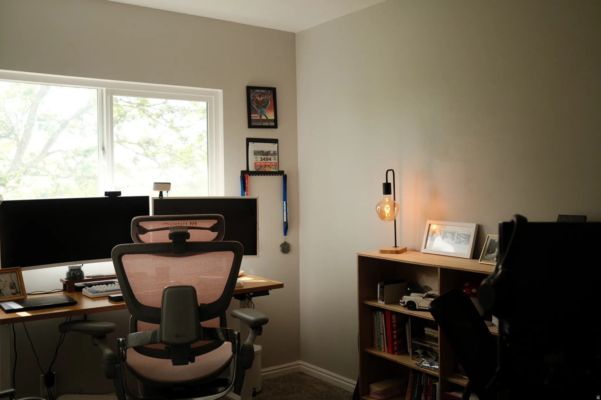Bright room featuring a large window, light-colored walls, and a built-in wooden shelving unit