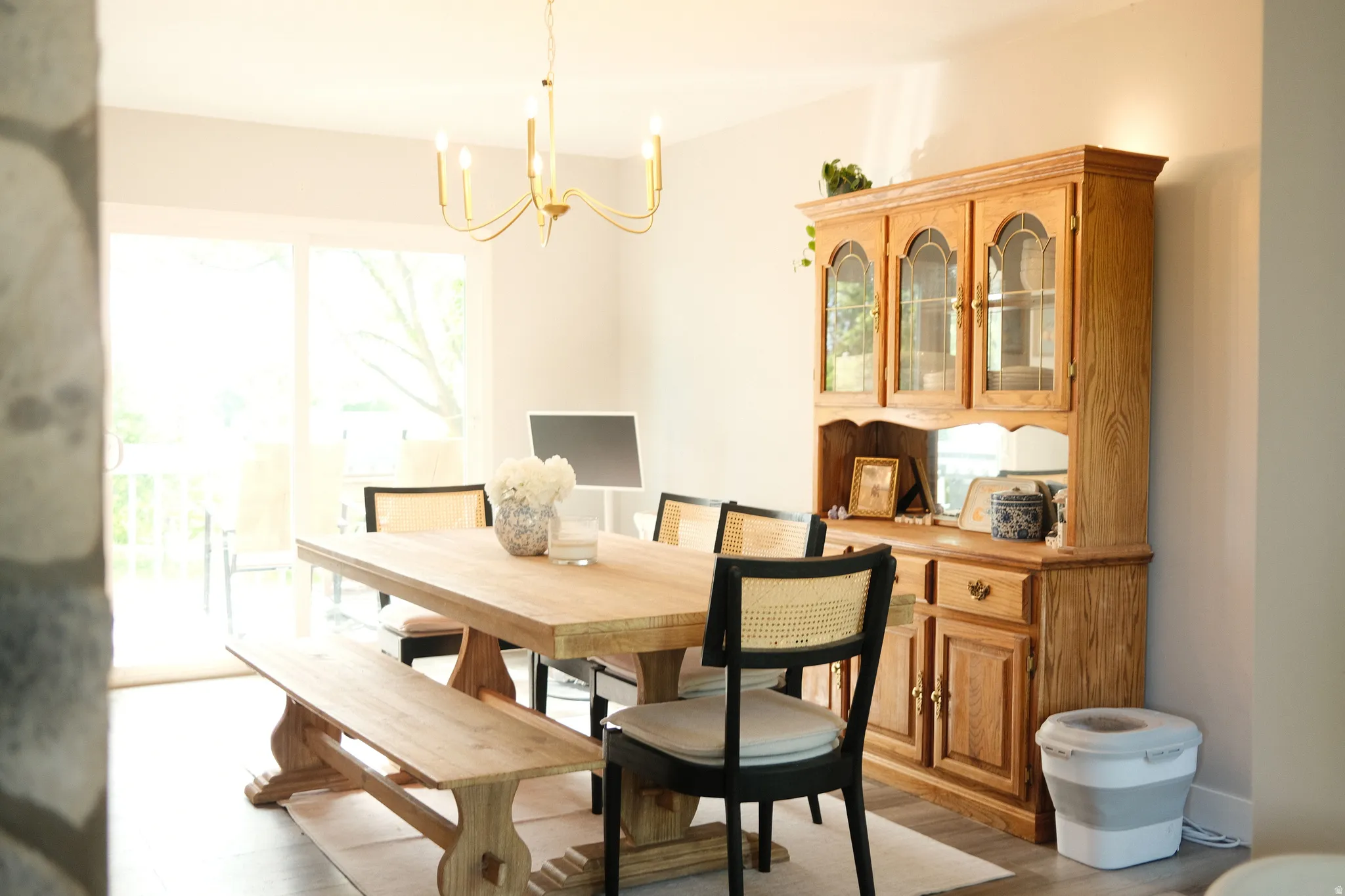 Dining area featuring light wood-finish flooring and a brass chandelier