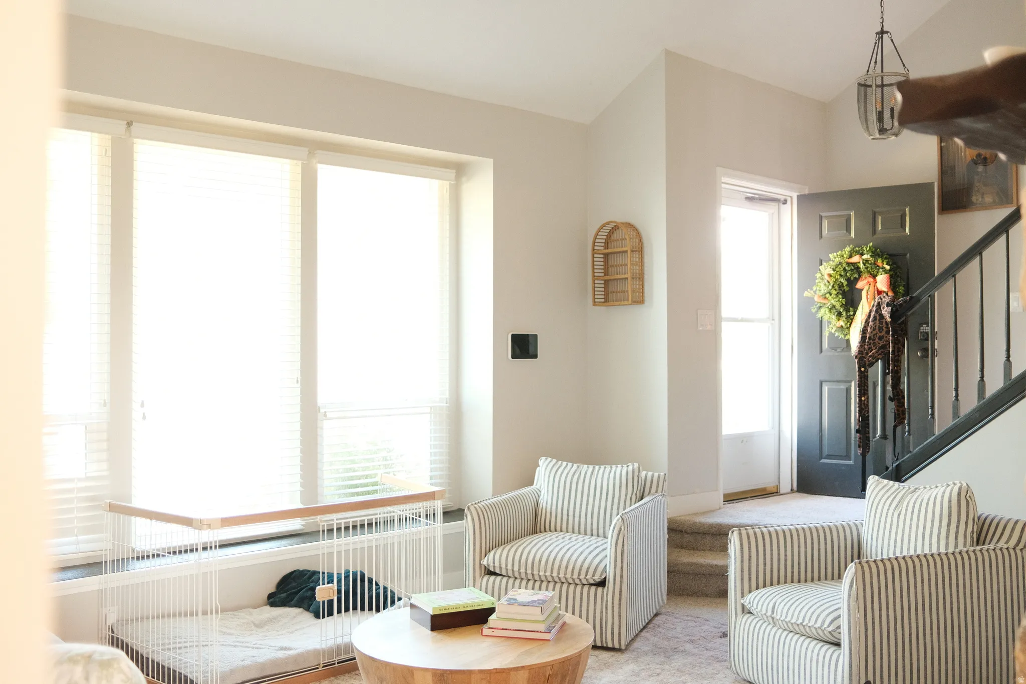 Bright living space featuring a large window with horizontal blinds, providing ample natural light