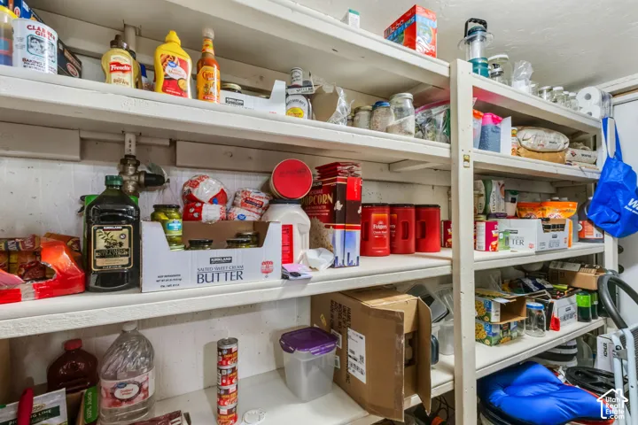 Utility room featuring built-in shelving and exposed piping