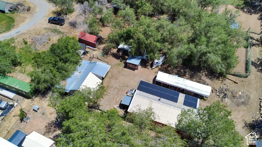 Aerial view of a property featuring multiple structures and natural landscaping