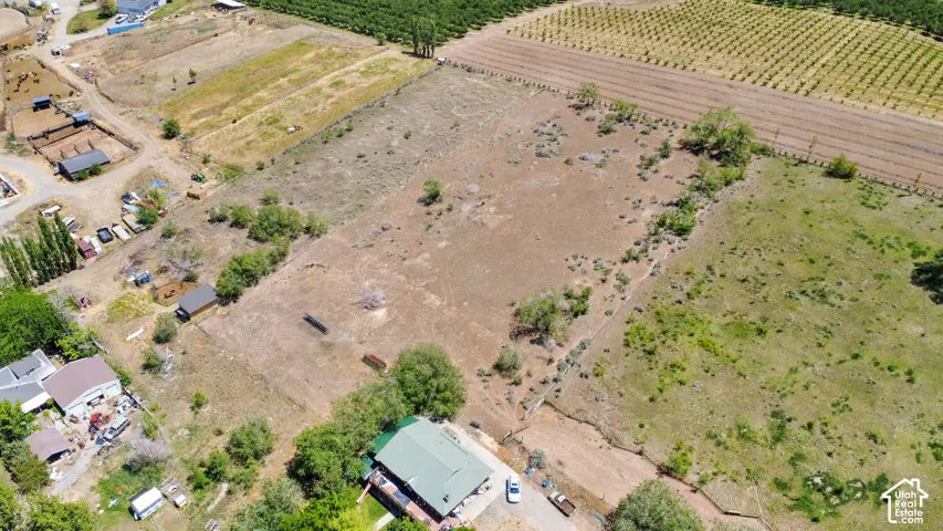 Expansive agricultural property featuring multiple outbuildings, varied terrain, and cultivated fields