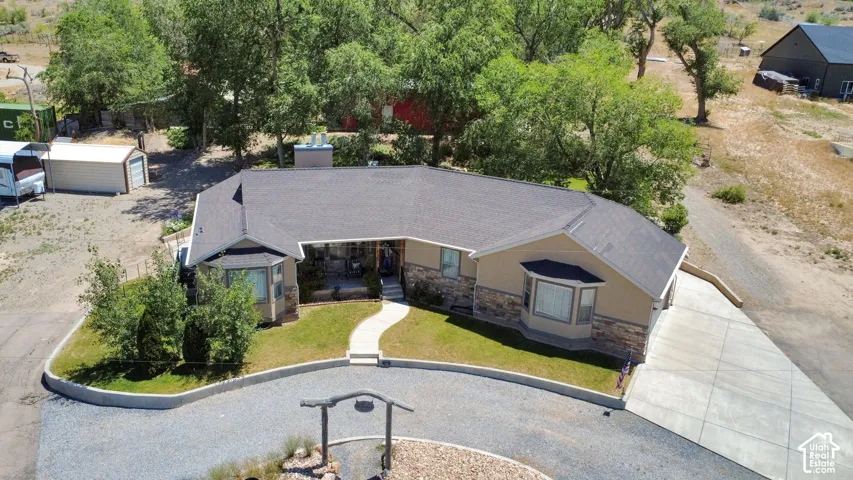 Single-story residence featuring a dark shingle roof and a stucco and stone veneer exterior
