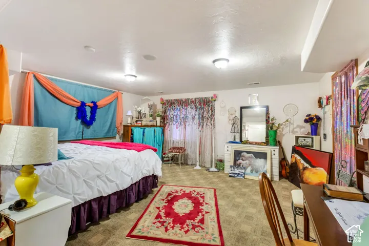 Carpeted interior space featuring white walls and a white ceiling with recessed lighting