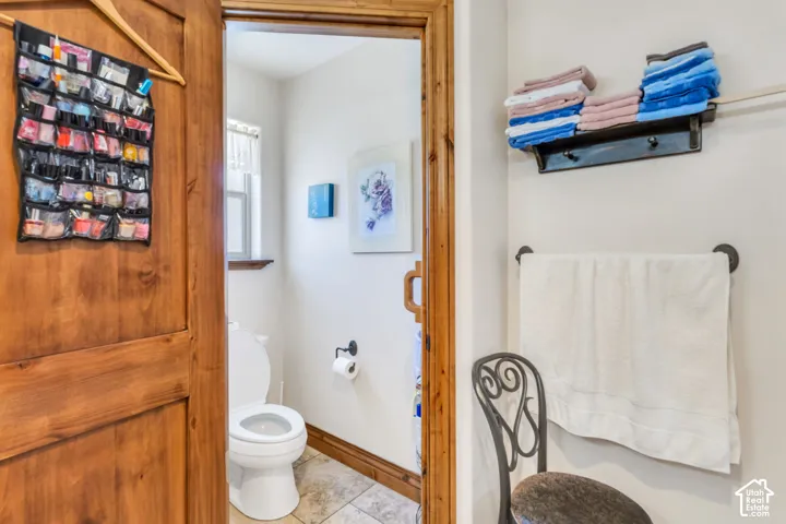 Powder room featuring a solid wood door, tile flooring and a window with a wood sill