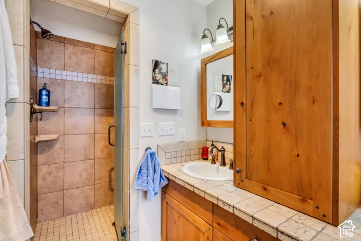 Shower with glass enclosure and tiled walls