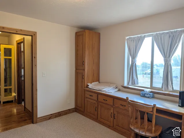 Built-in wood-finish cabinetry featuring a long desk surface and multiple storage options