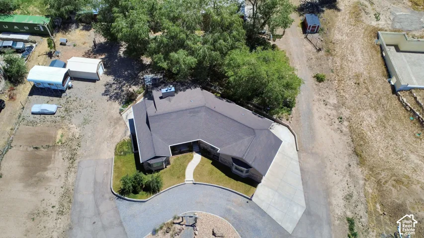 Single-story residence featuring a dark shingle roof and a curved stone-edged driveway