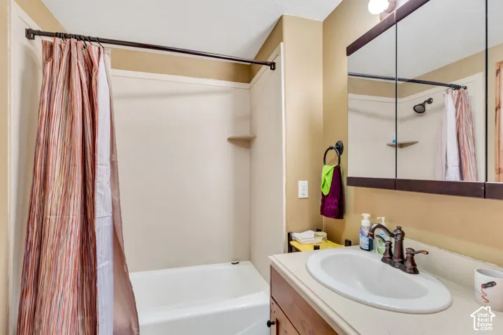 Bathroom featuring a white bathtub and shower combination with an integrated shelf
