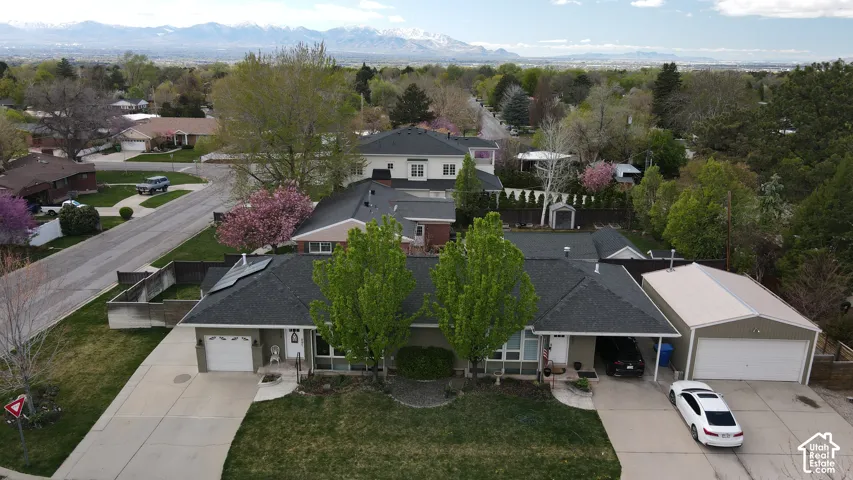 Twin dwelling exterior featuring individual driveways, attached garages, and mature landscaping