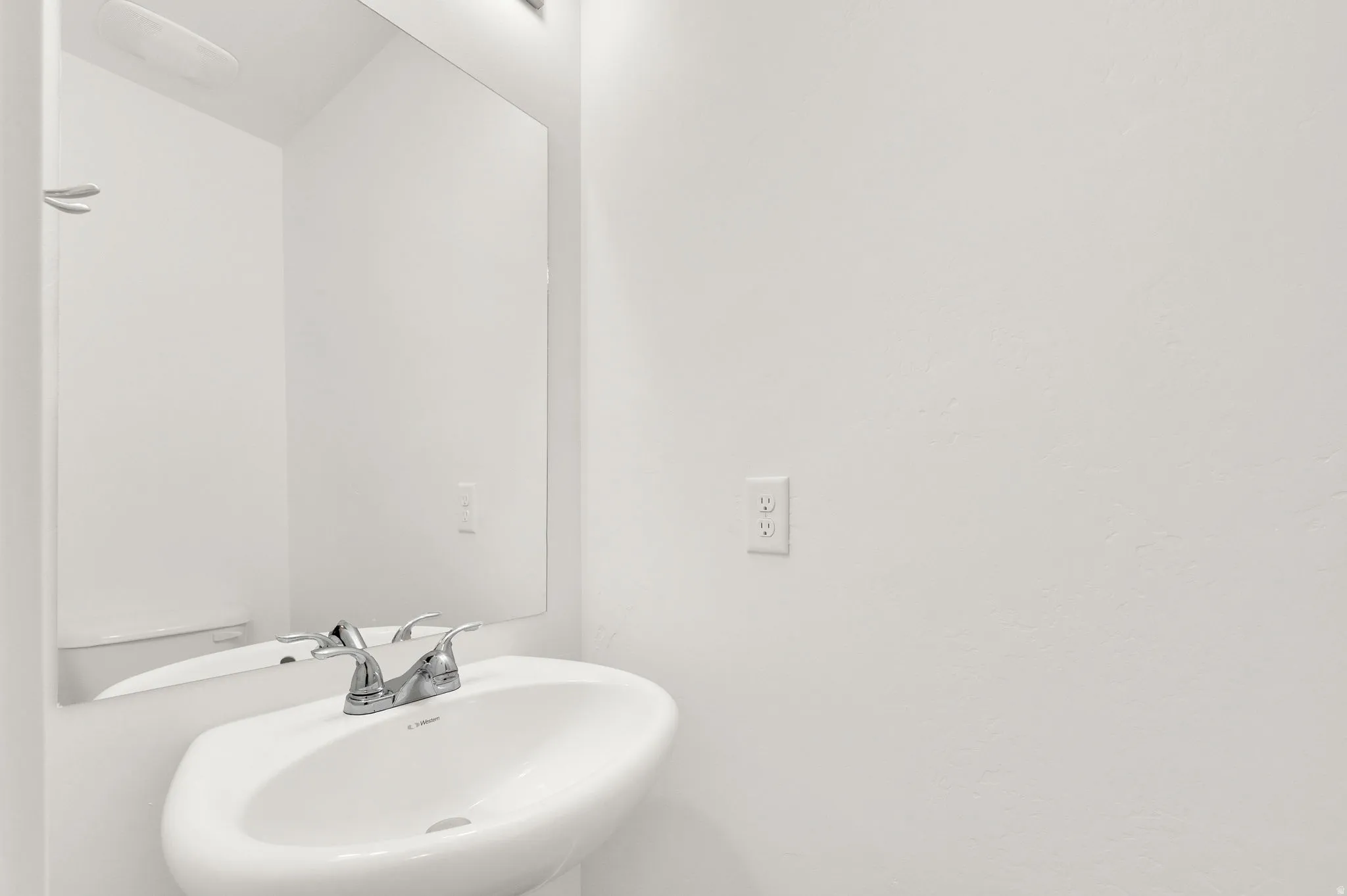 Pedestal sink with a polished chrome faucet and an integrated basin