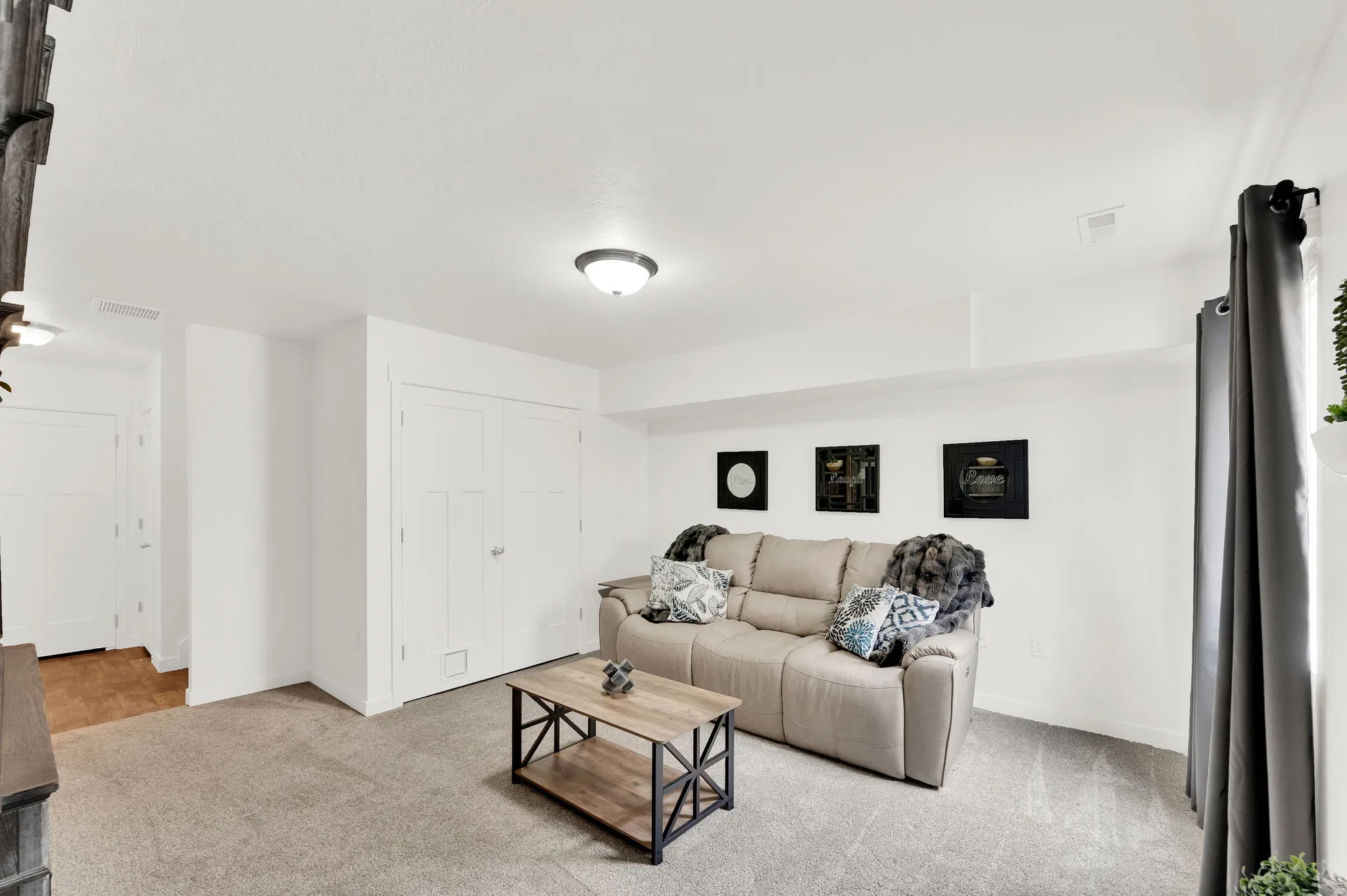 Carpeted room with a flush-mount ceiling light and white walls