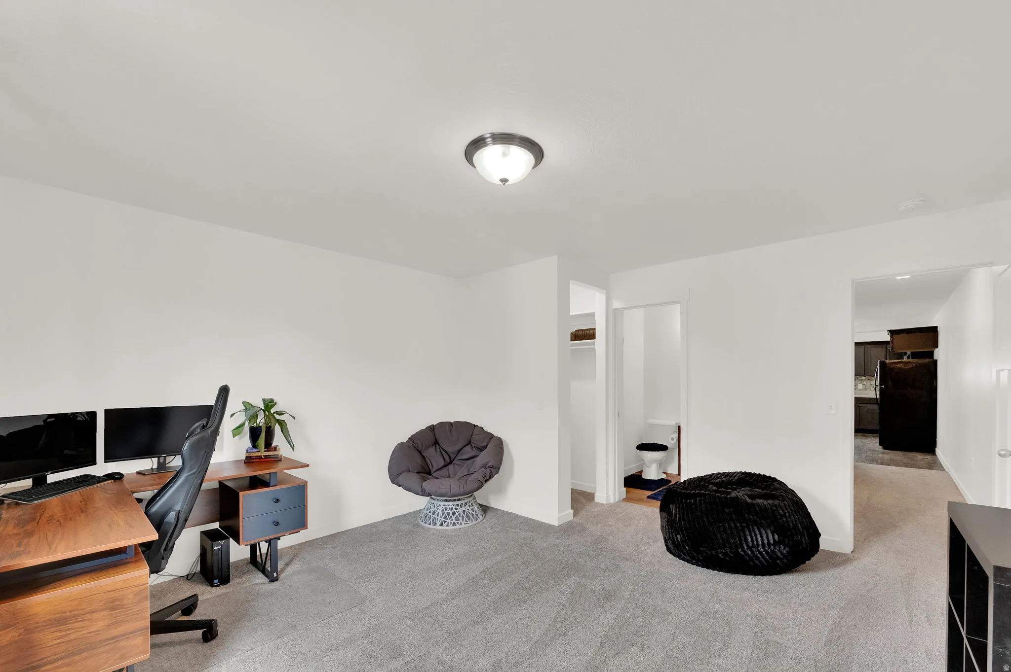 Spacious room featuring light gray carpeting and white walls