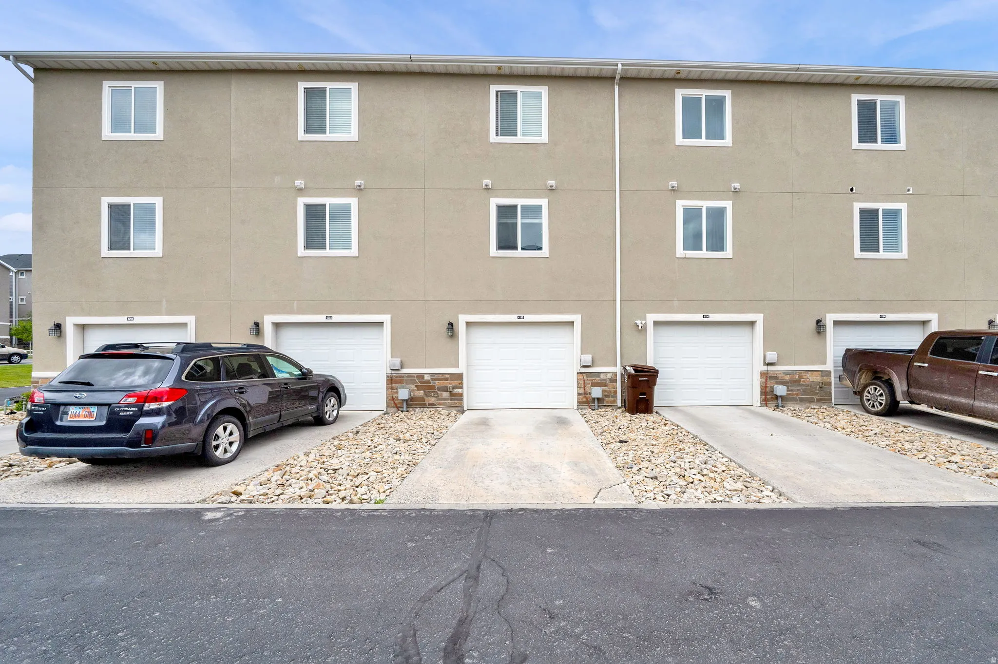 Multi-story exterior with a stucco facade and white-framed windows