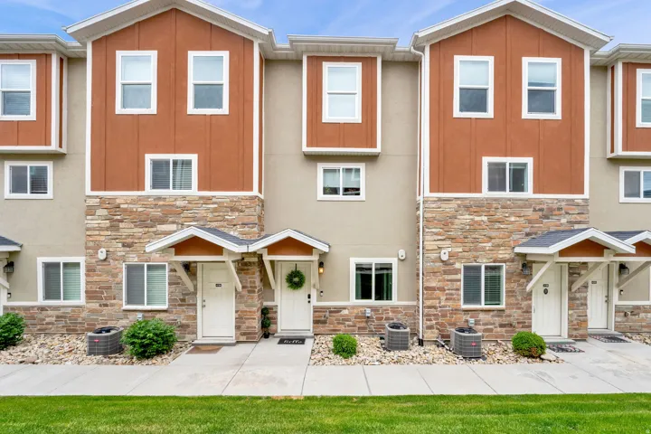 Townhome exterior featuring earth-toned siding and stone veneer accents