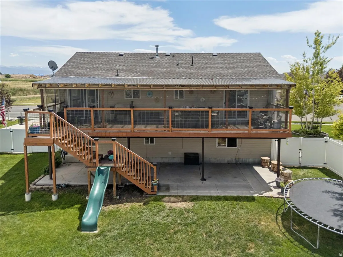 Rear exterior featuring a two-story design with a screened-in upper deck and an open-air lower patio