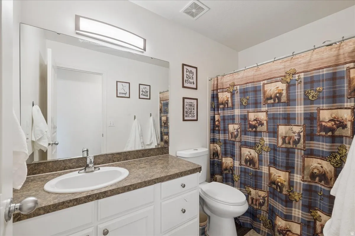 Bathroom featuring a vanity with a textured countertop, undermount sink, and chrome-finish faucet