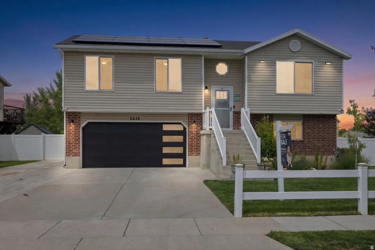 Split-level exterior featuring light-colored siding and brick accents