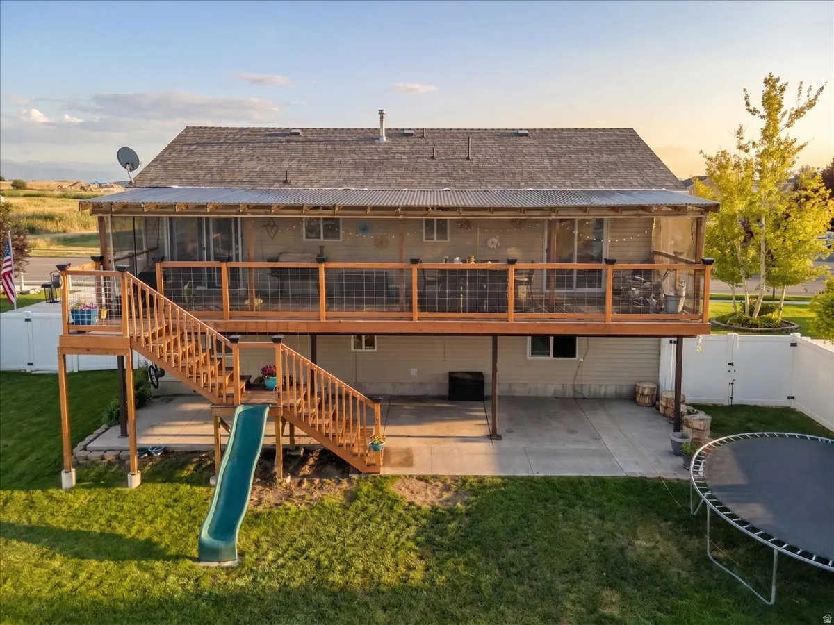 Spacious backyard featuring a multi-level wooden deck with staircase access to the lawn