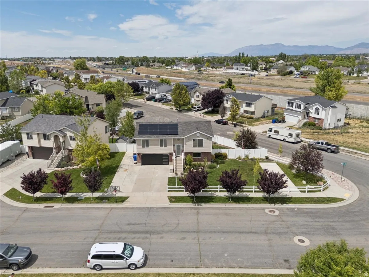 Two-story residence featuring a neutral-toned exterior, a front-facing garage, and solar panels