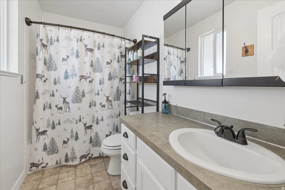 Bathroom featuring a single vanity with an oval sink, dark bronze-finish faucet, and a large medicine cabinet mirror