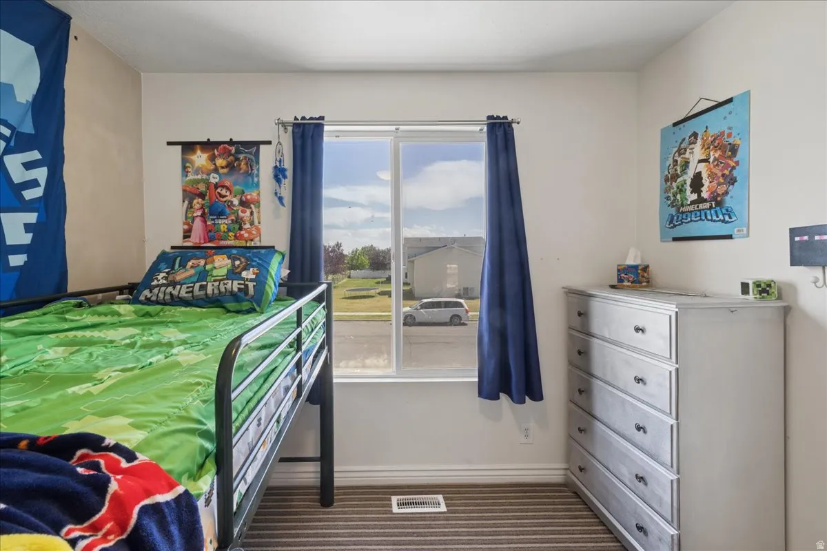 Room featuring a window with natural light, neutral wall paint, and striped carpet flooring