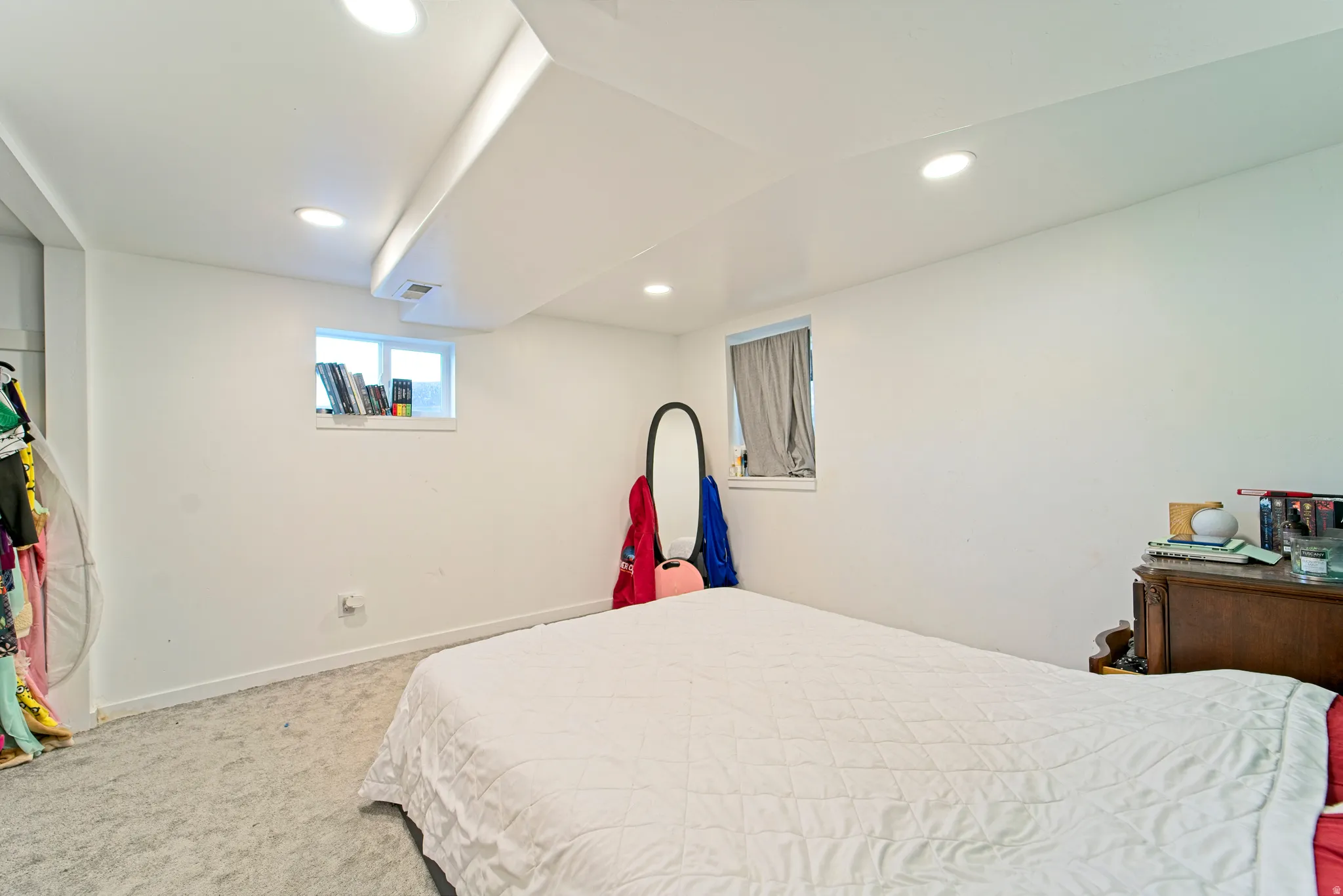 Bedroom featuring white walls, recessed ceiling lighting, two windows, and light-toned carpeting