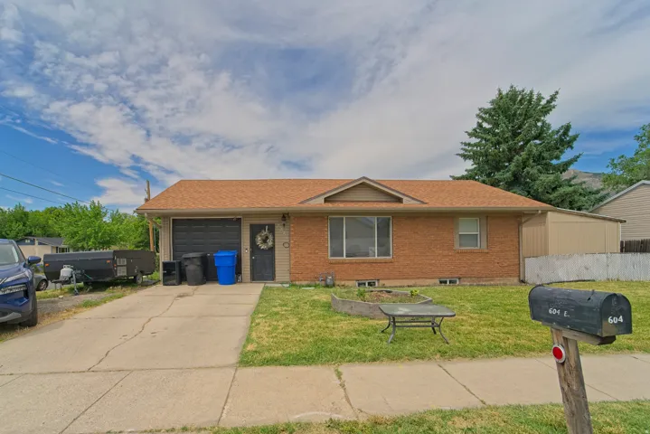 Brick exterior residence featuring an attached garage and a concrete driveway