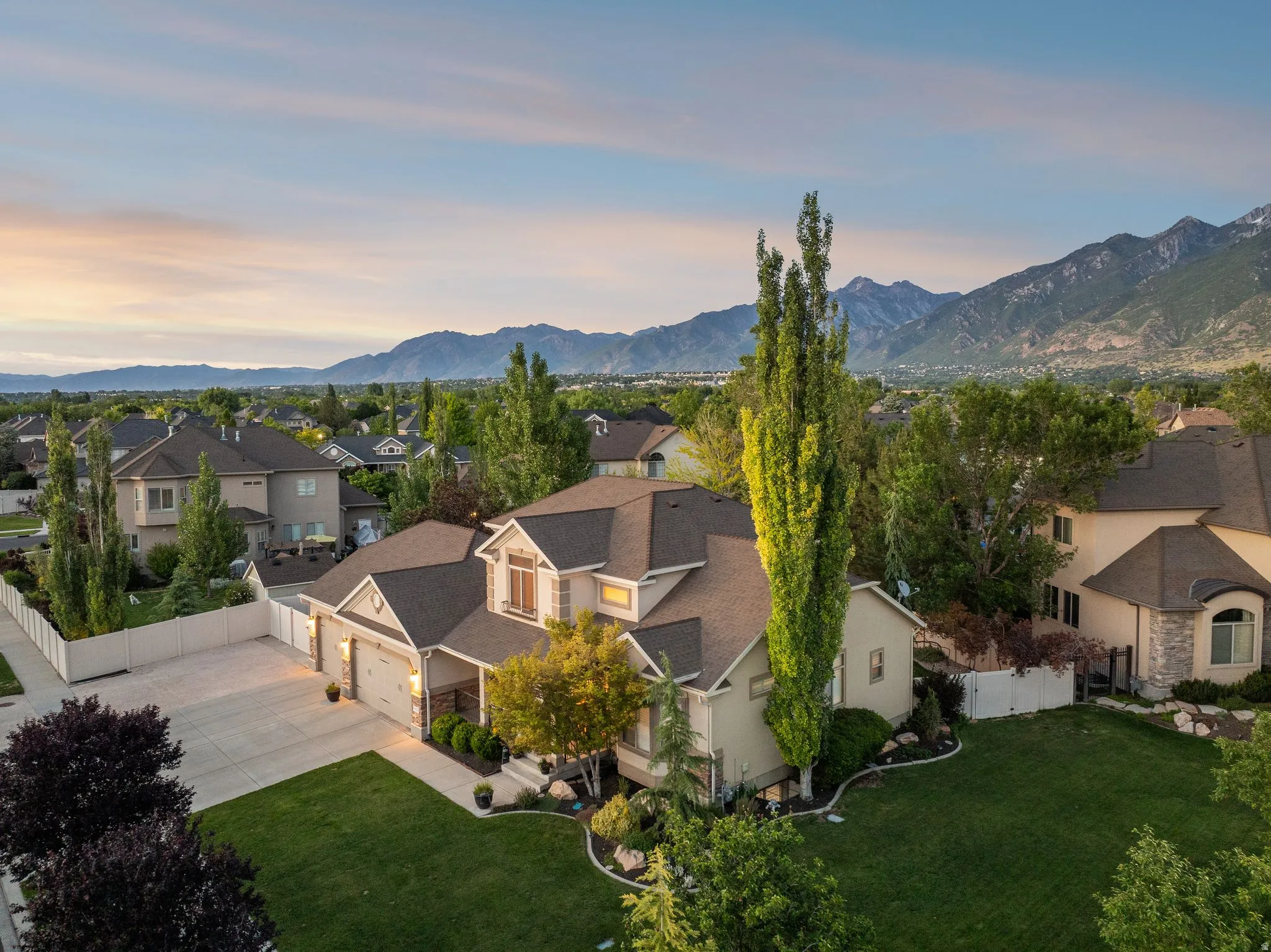 Expansive residential property featuring a large front lawn, a multi-car driveway, and a two-story architectural style
