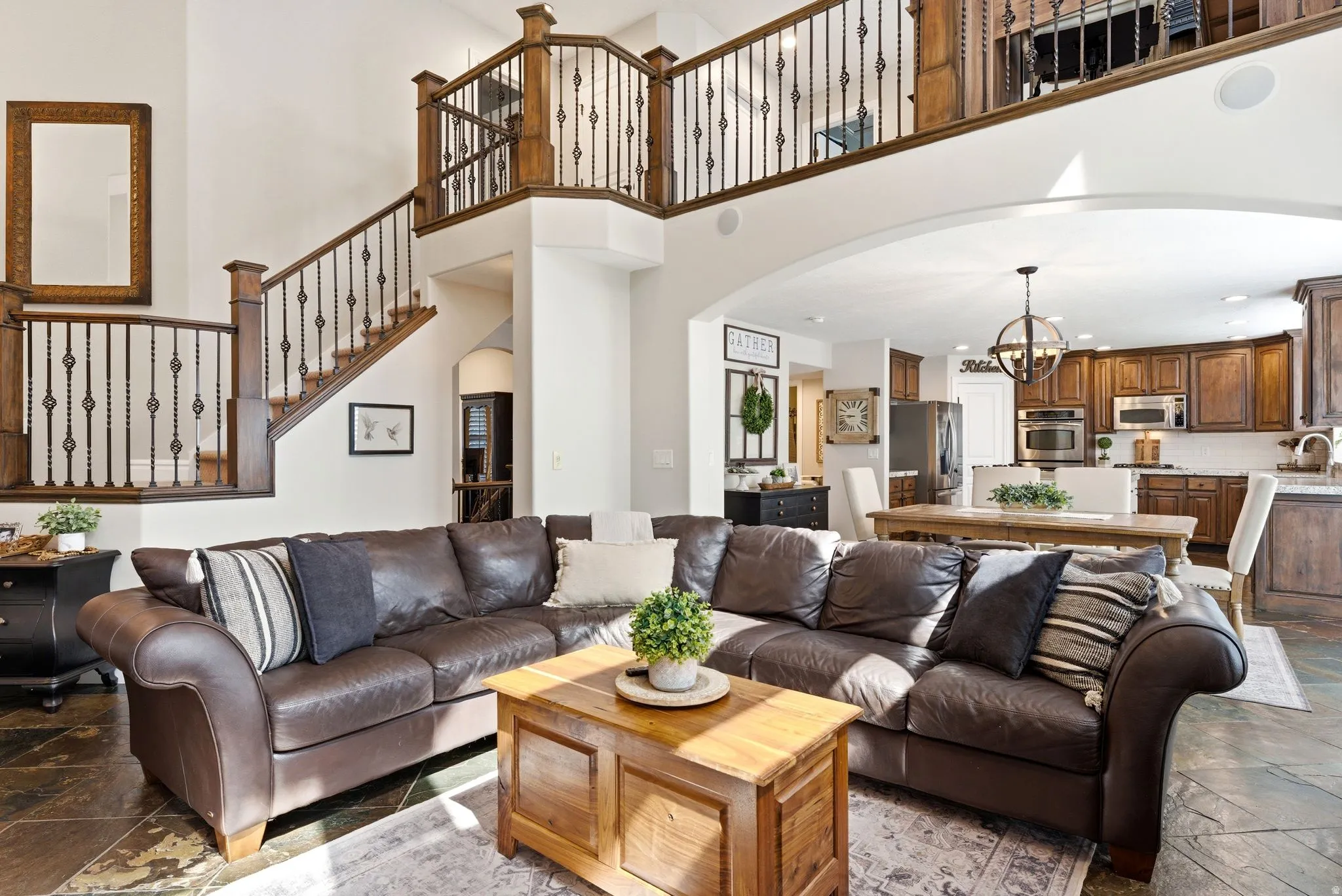 Open-concept living area with high ceilings and a visible upper-level loft landing