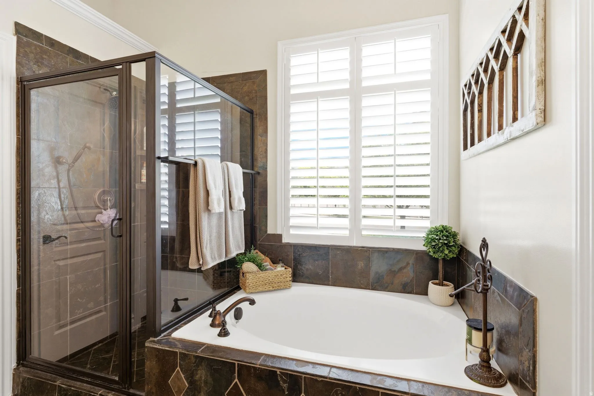 Primary bathroom featuring a built-in soaking tub and separate glass-enclosed shower