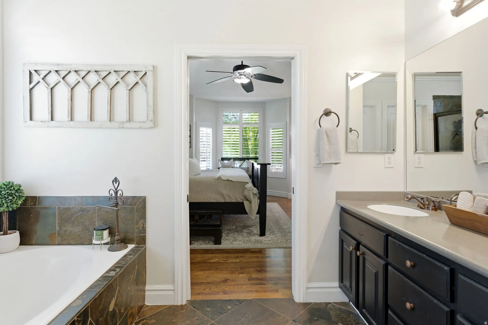Primary bathroom featuring a built-in tub with natural stone tile surround