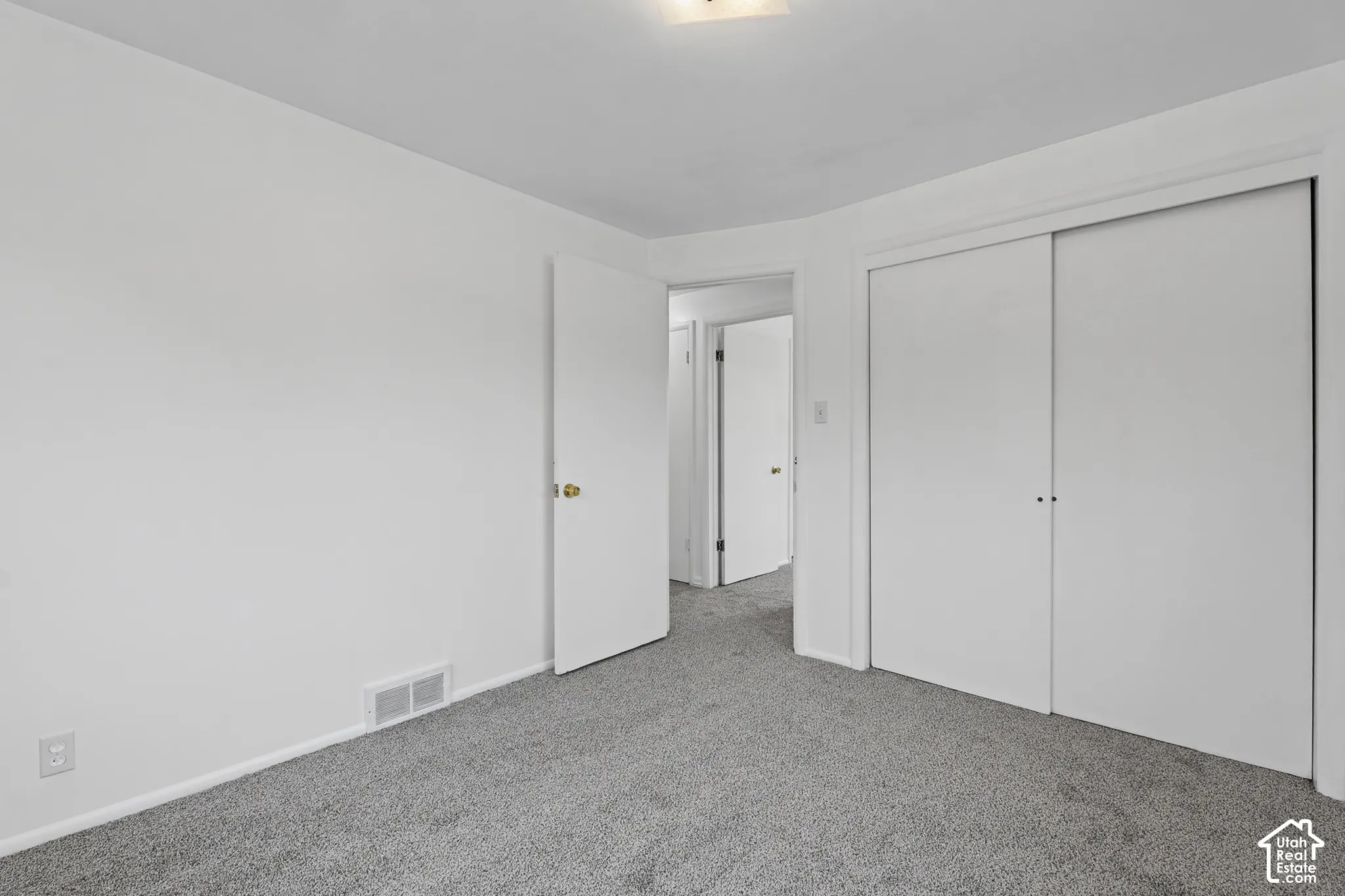 Bedroom 3 Plush grey carpeting with clean white walls and trim, featuring a sliding double-door closet
