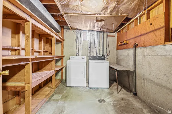 Laundry area featuring concrete flooring and a floor drain