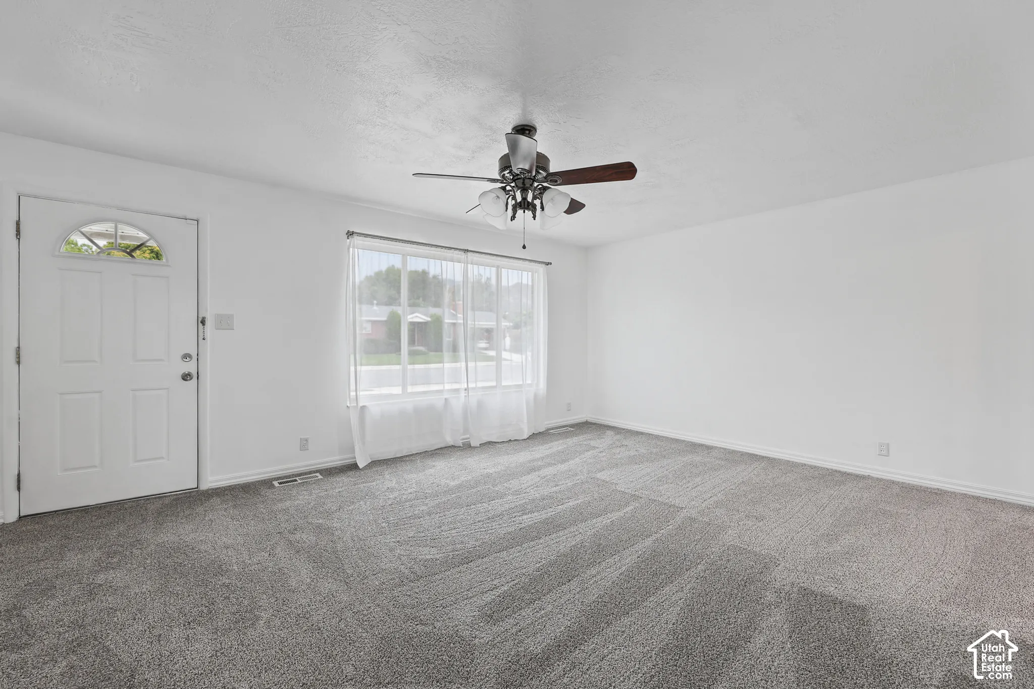 Recessed lighting, ceiling fan, carpeting, and a window with sheer curtains