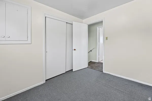 Room with light-colored walls and gray carpet flooring