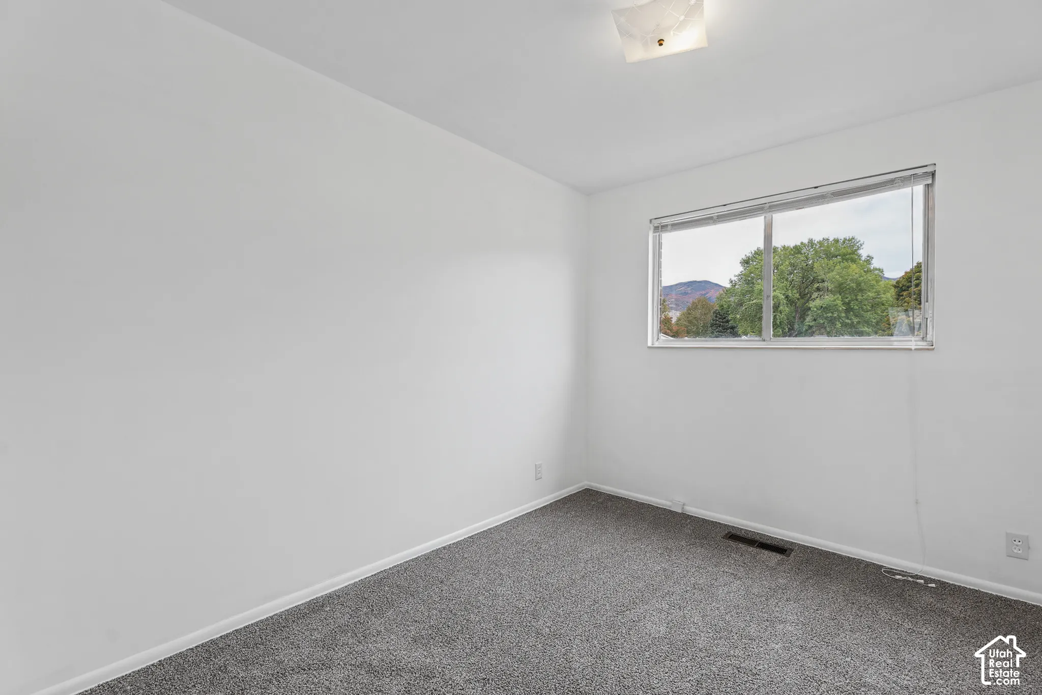 Bedroom 1 Neutral wall color, carpeted flooring, and a large window