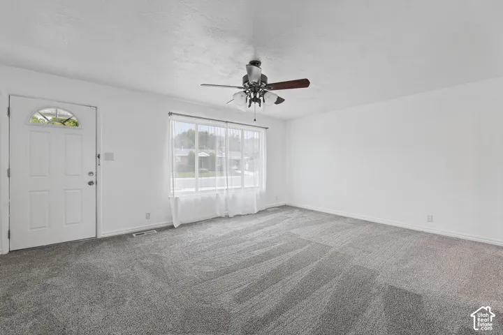 Recessed lighting, ceiling fan, carpeting, and a window with sheer curtains