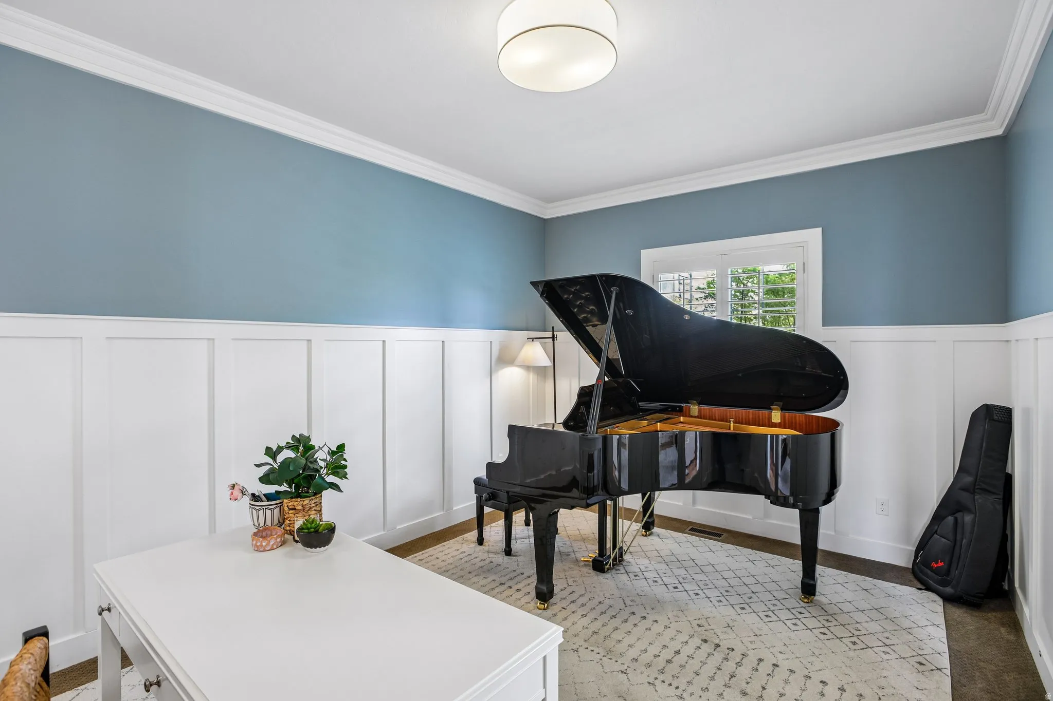 Room featuring a combination of board and batten paneling and painted walls, crown molding, a window with exterior views, and a flush-mount ceiling light fixture