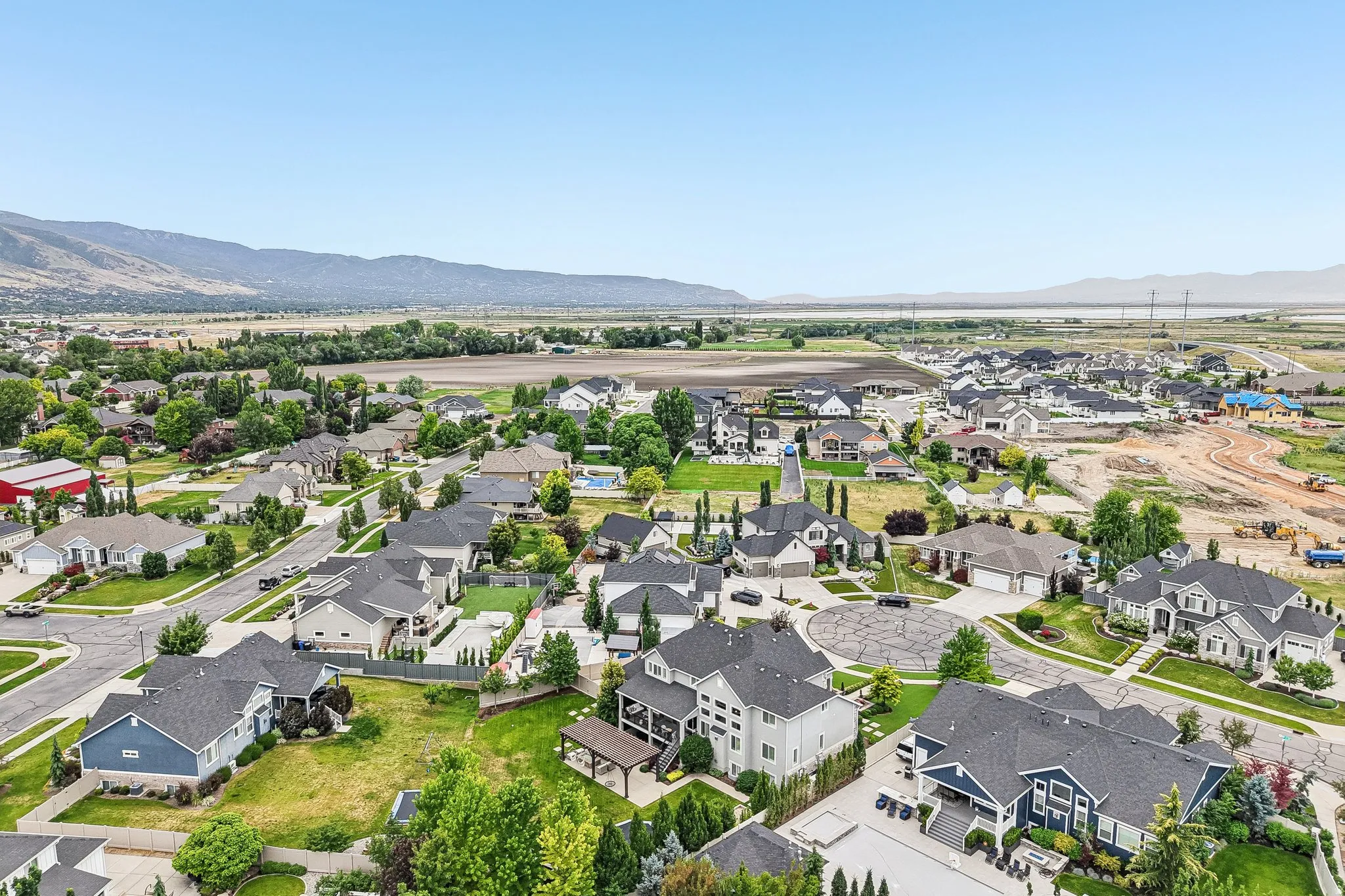 Expansive residential area with a variety of architectural styles, surrounded by green landscapes and distant mountains