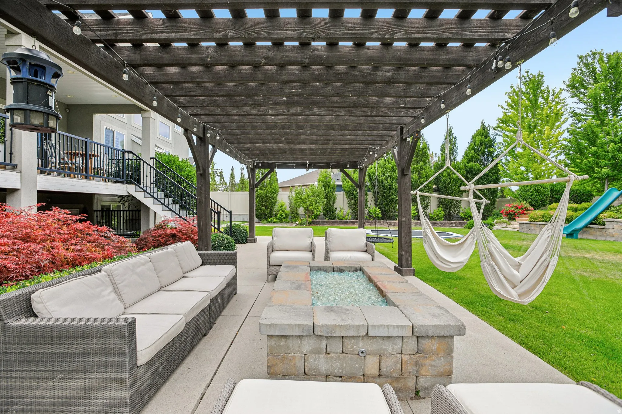 Expansive patio featuring a wood pergola and concrete paver flooring