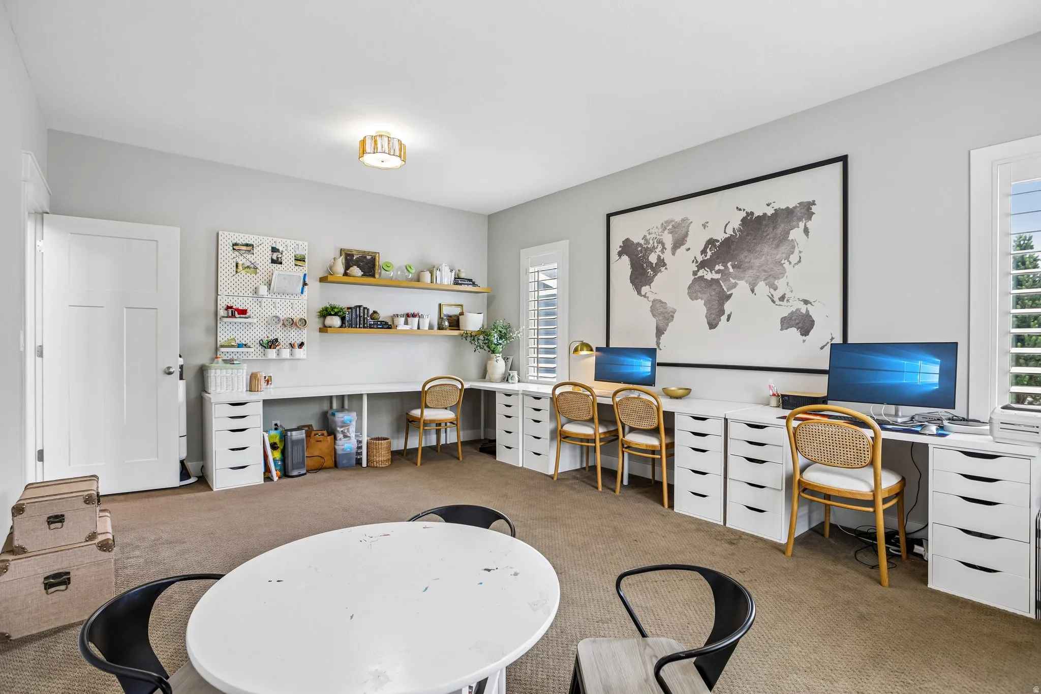 Spacious room featuring extensive built-in desk space, multiple storage drawers, and integrated shelving