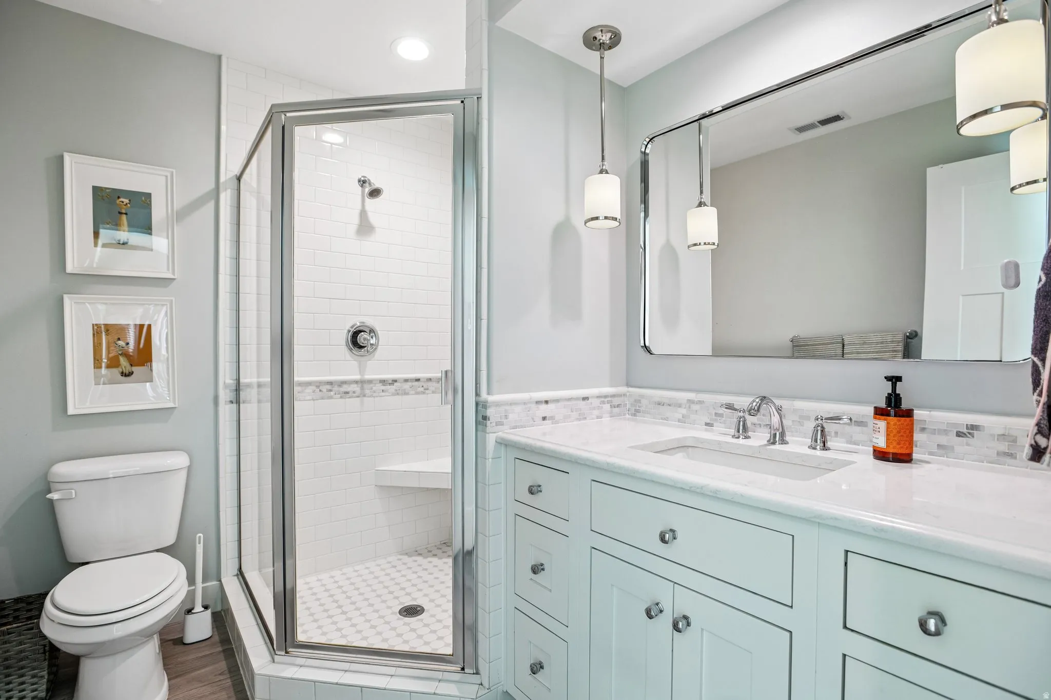 Bathroom featuring a glass-enclosed shower with white subway tile, a built-in shower bench, and a mosaic tile accent strip