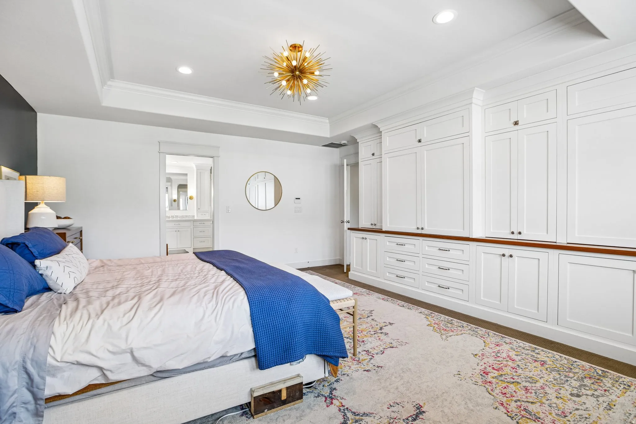 Built-in cabinetry with wood-finish countertop, recessed lighting, and tray ceiling with a contemporary light fixture