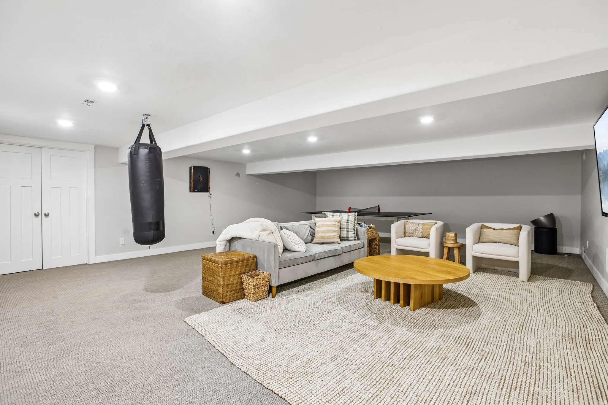 Spacious lower level featuring recessed lighting, carpet flooring, a built-in wall speaker, and double panel doors